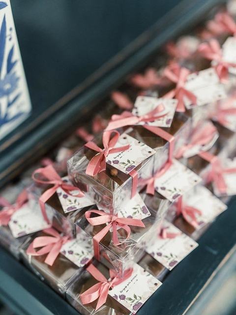 Caixinhas de brownie com laço rosa e tag floral para casamento